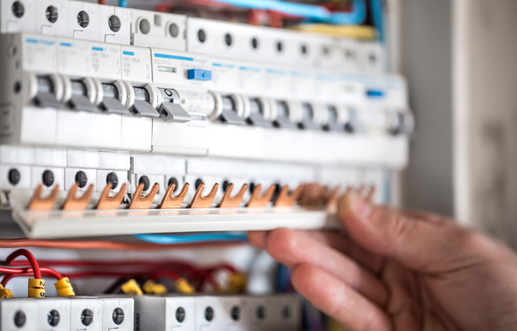 Electrician working on circuit breakers in a consumer unit